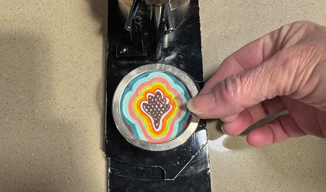 Step 4 in Button Making 101 is to place your design on top of the shell and place the mylar on top of the design