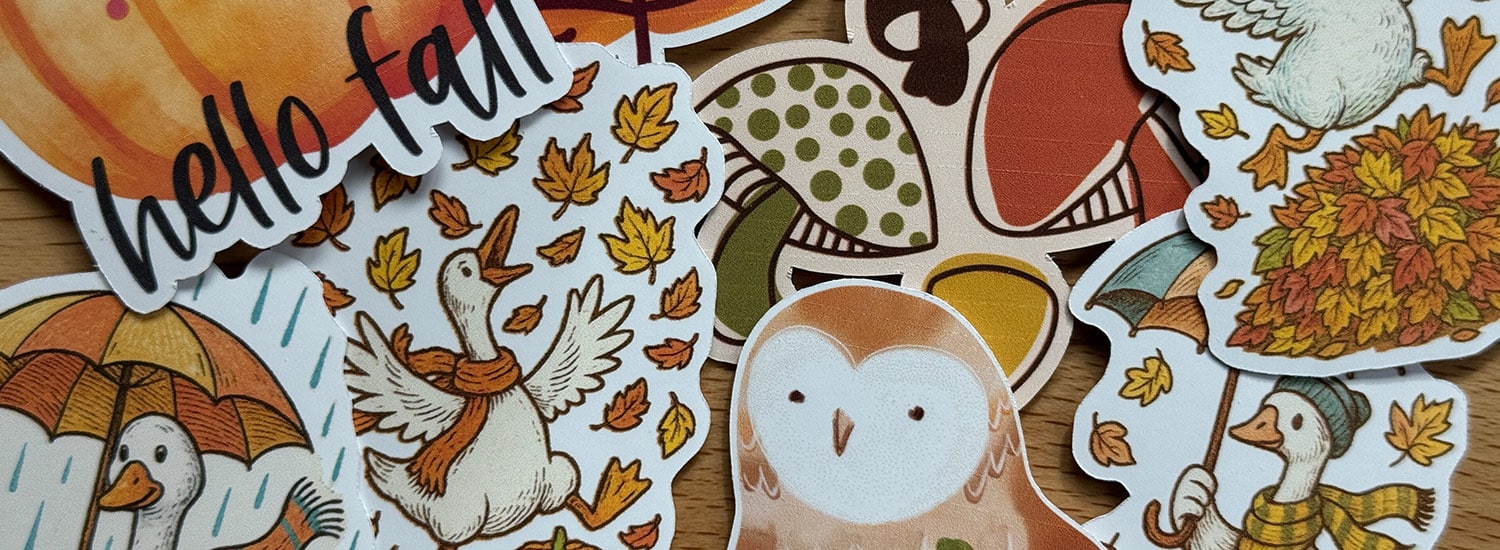 Assorted Fall themed Cricut stickers arrayed on a table