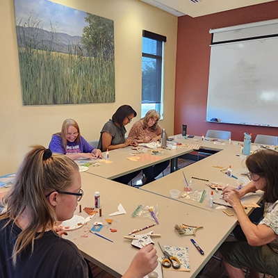 A group of patrons sitting around a large table working on crafts at the Hudson Public Library