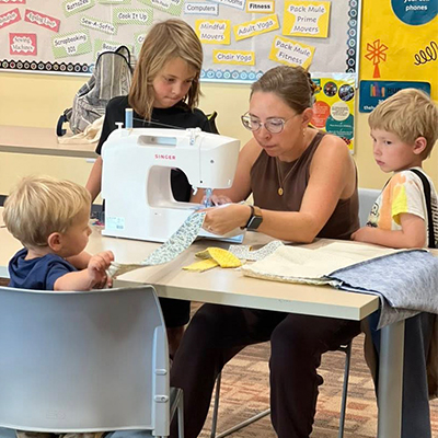 Mother and her children work on a family sewing projects at the Hudson Public Library