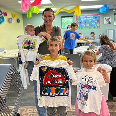 Mother and her three children show off the custom tee shirts they made during a Family Program at the Hudson Public Library