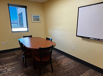 The Hudson Public Library Study Room with one table, four chairs, a whiteboard, and a window